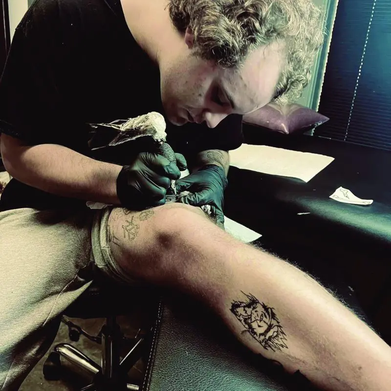 Person tattooing their leg