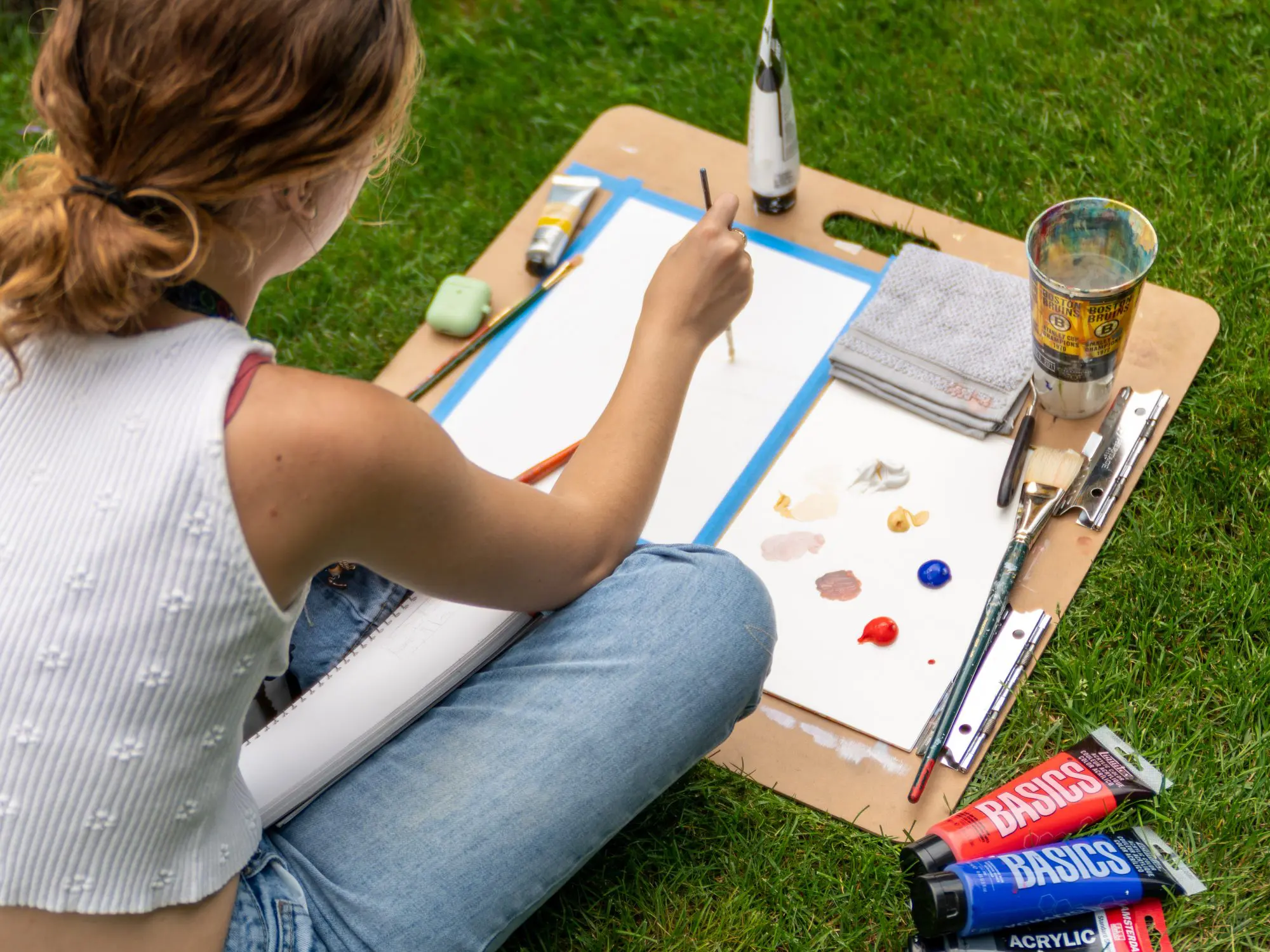 Someone sitting outside painting