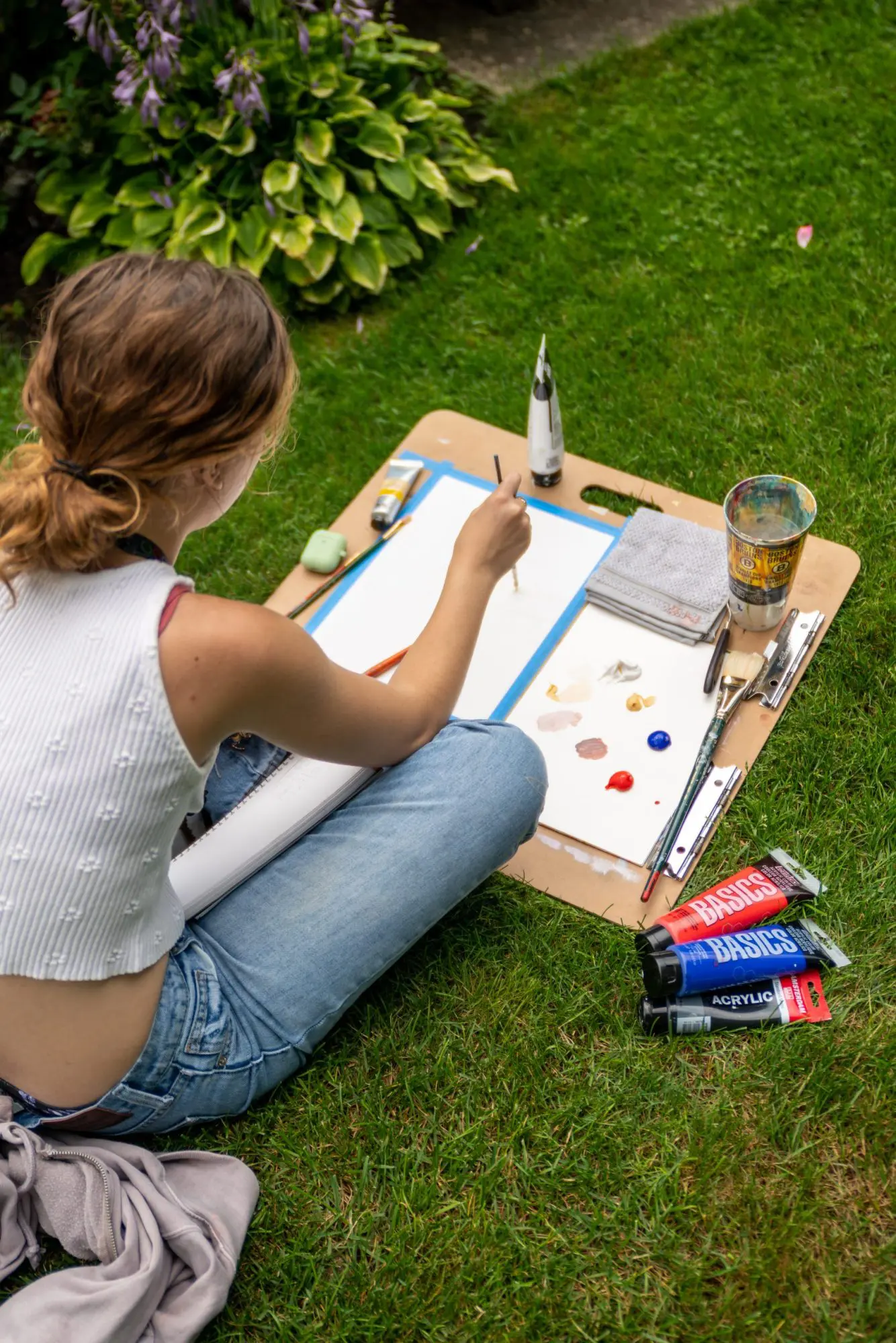 Someone sitting outside painting