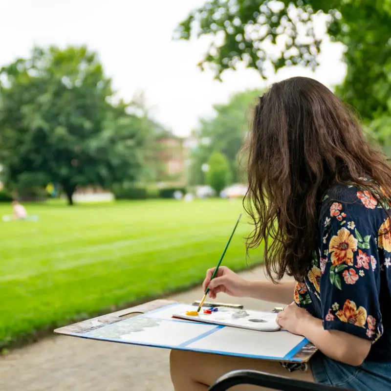 A person painting in a park