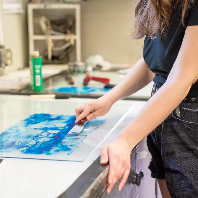 A person spreading ink for printmaking