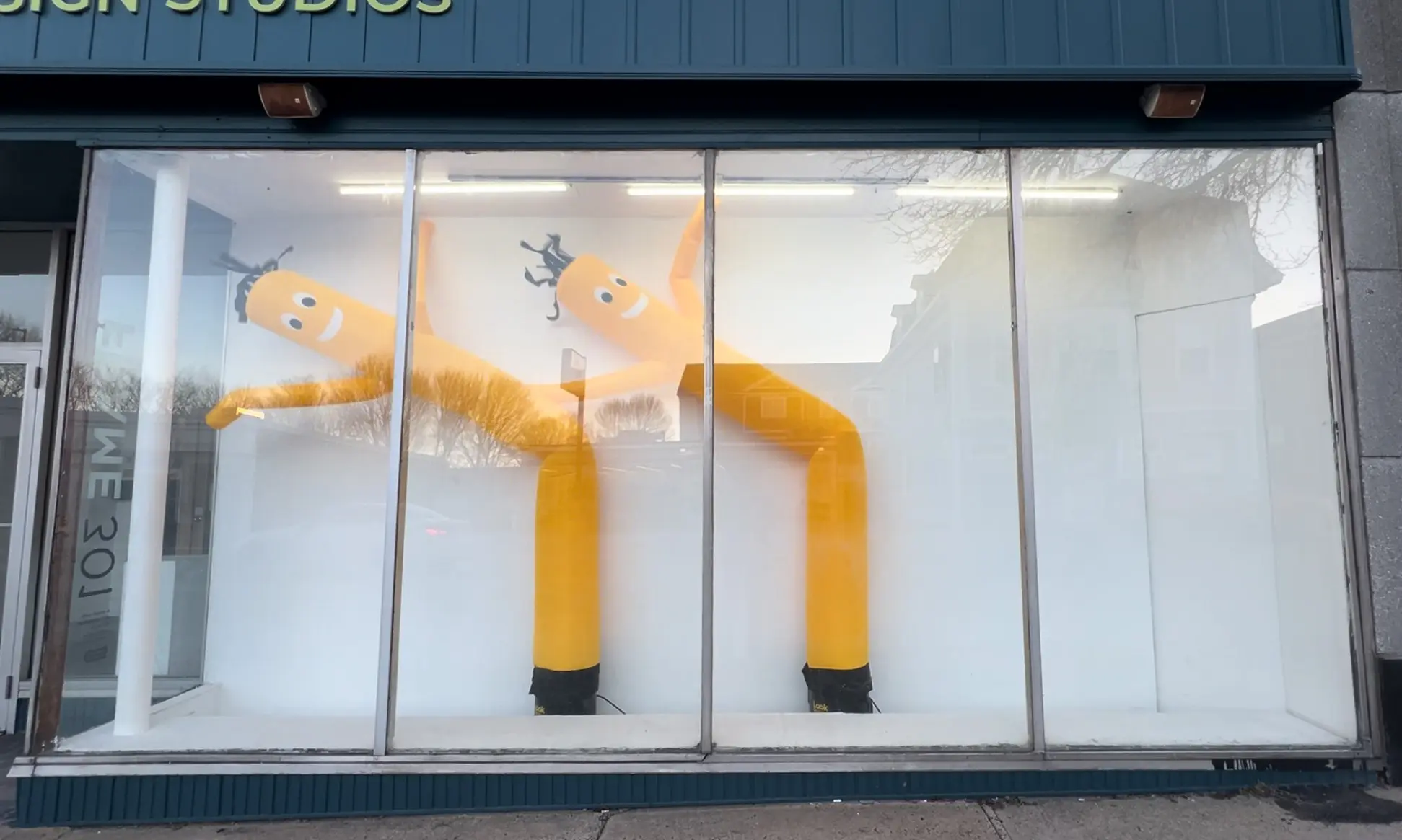 Two yellow Air Dancers® inside of the 301 Frame Gallery