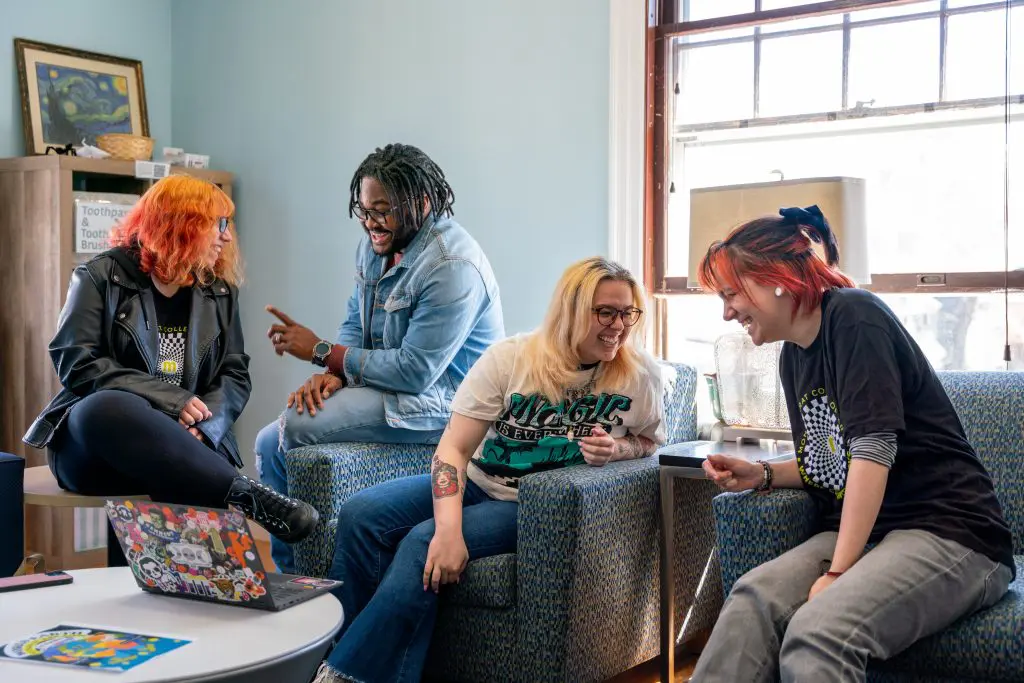 four students sitting in a lounge laughing