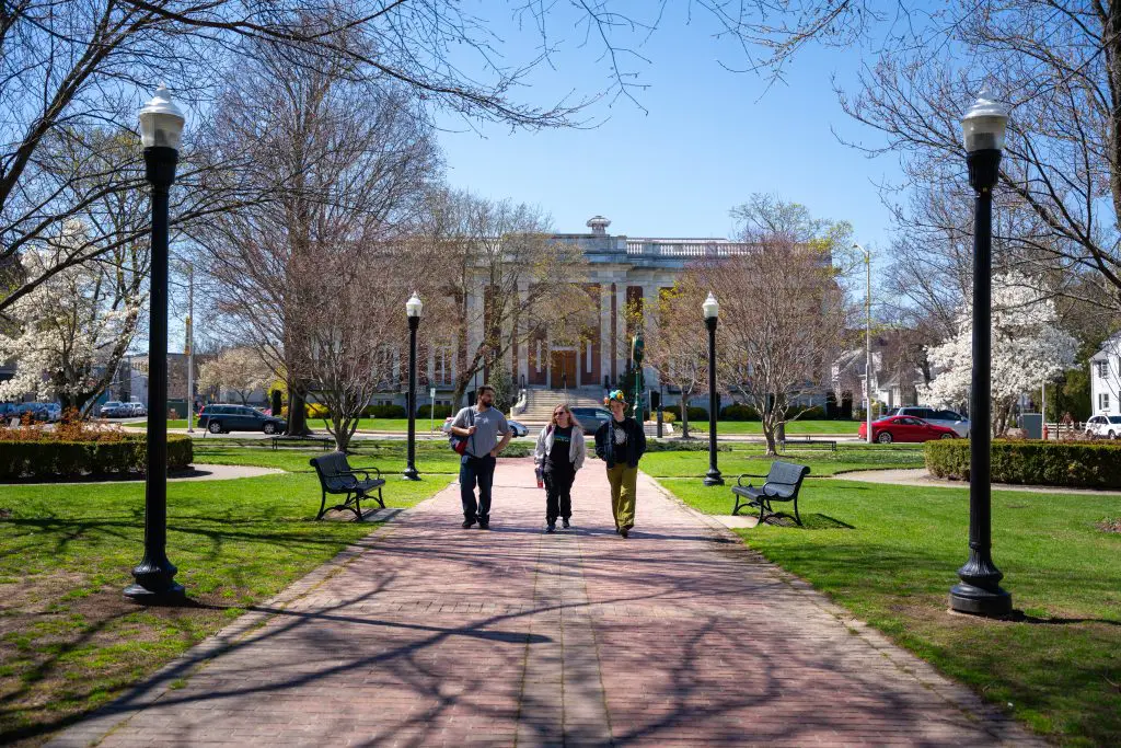 three students walking in the town park