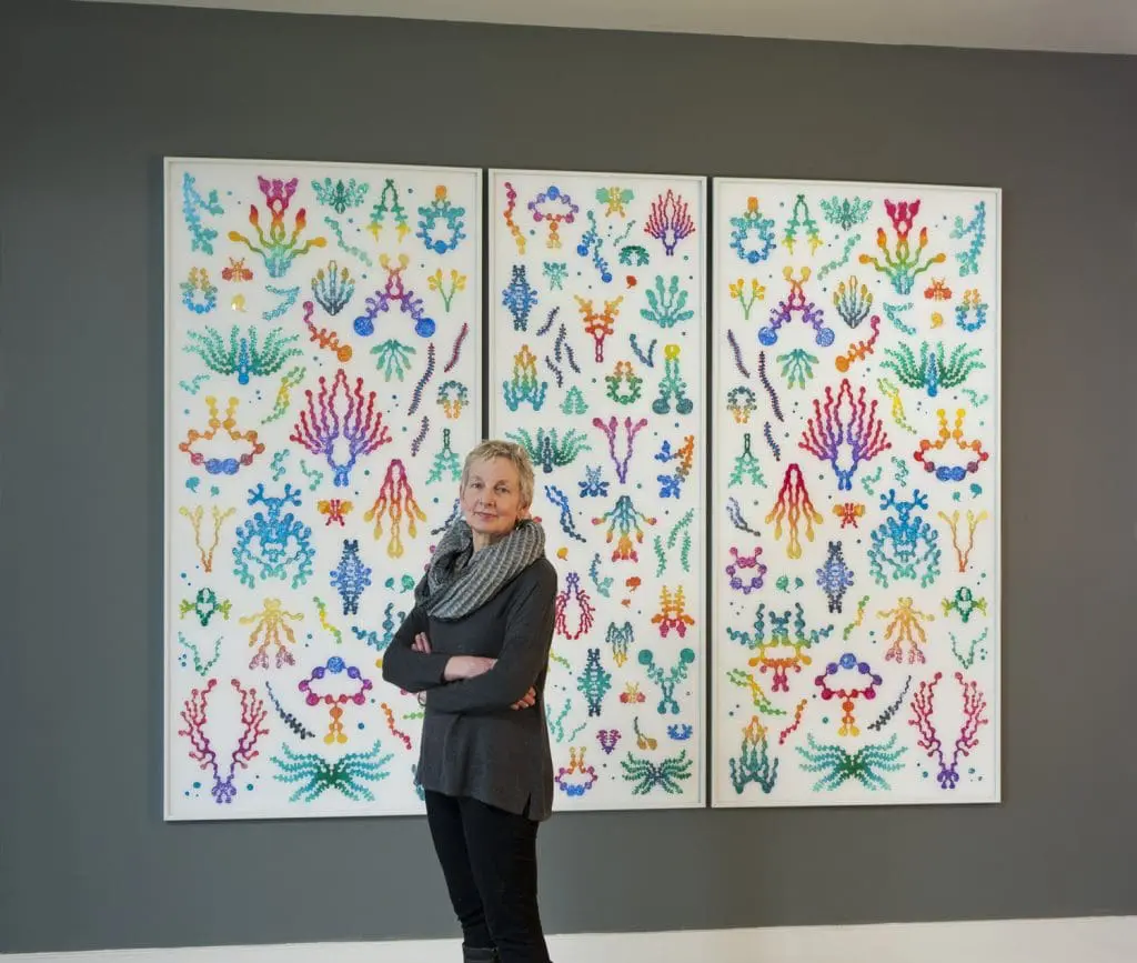 artist standing in front of her painting