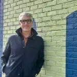 man leaning against a brick wall