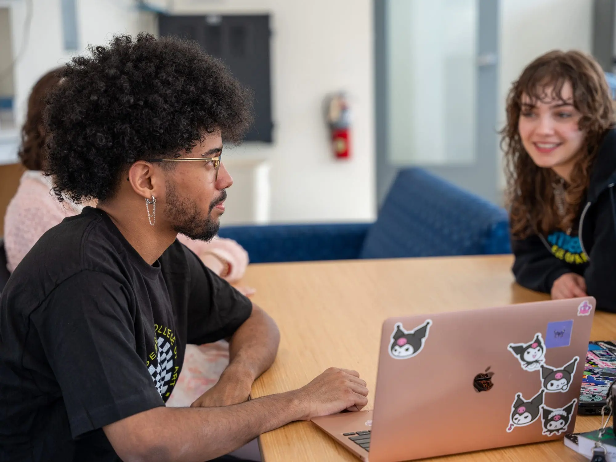 two students talking at a table