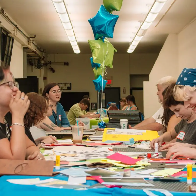 A group of alumni working with paper