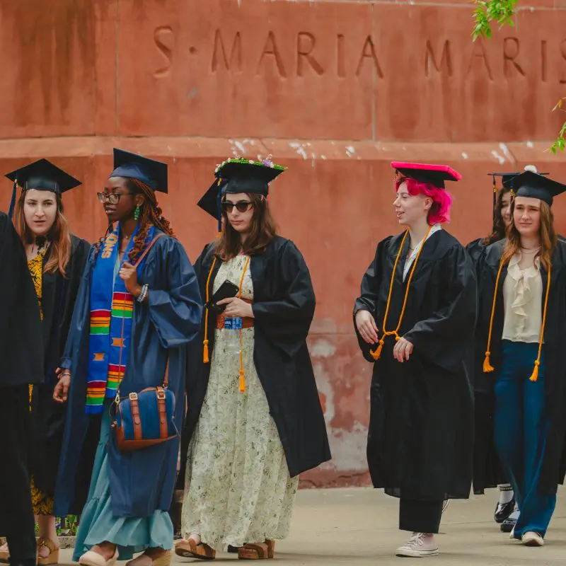 Students walking in graduation caps and gowns