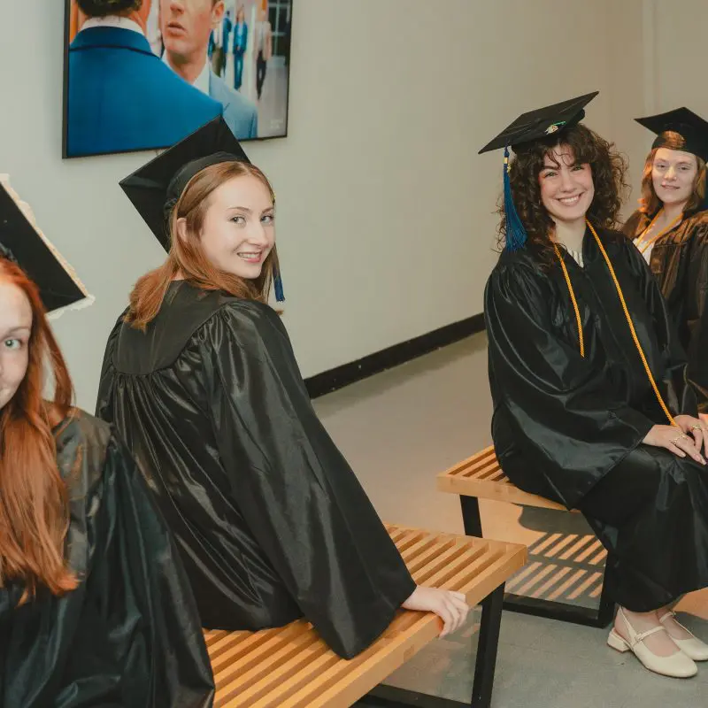 Students sitting in graduation caps and gowns