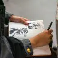 hands drawing in a sketchbook
