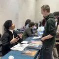 student at college fair having his portfolio reviewed