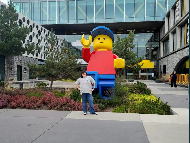 person standing in front of a LEGO statue outside