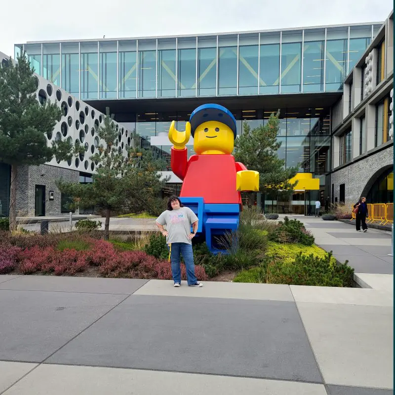 person standing in front of a LEGO statue outside
