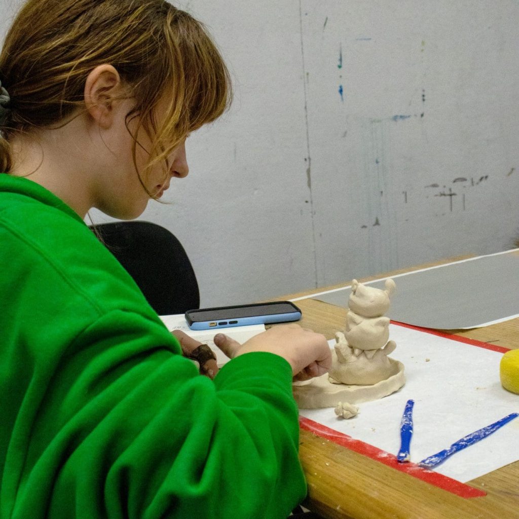 young person making clay art