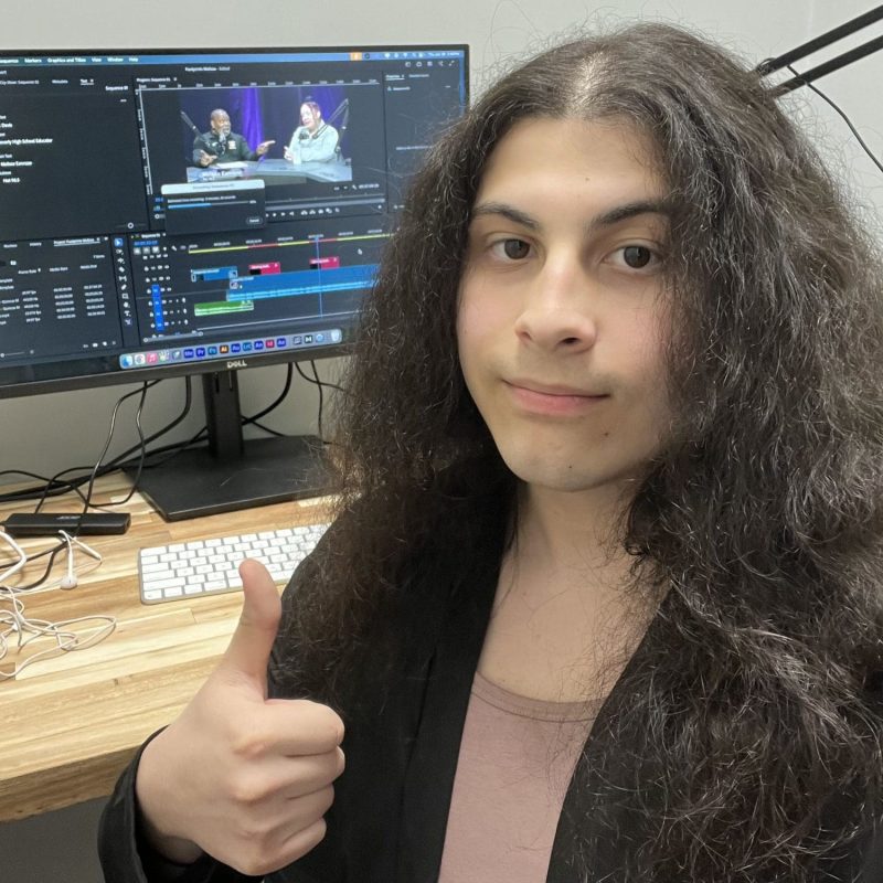 student giving thumbs up in front of computer