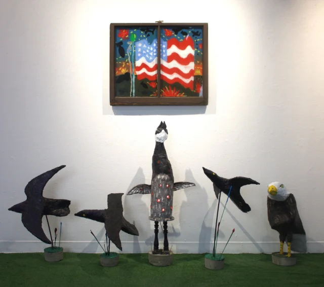 Campbell McLean: War-Birds & Adverts
Frame 301 Gallery
301 Cabot Street, Beverly, MA
July 13 - October 3“War-birds & adverts dance across my screen – like the birds of paradise.
Mechanical marvels of stolen avian secrets. Ailerons and fuselage.
Their hollow bones will be broken and poisoned by beasts created in their image.”
–Campbell McLeanCampbell McLean explores her queer-American experience by creating caricaturist paintings, objects, installations, and videos. From oil on canvas, papier-mâché to found object, McLean’s unique aesthetic approach shines through in her sporadic ‘make-due’ energy that flows seamlessly between 2D and 3D forms. The resulting works are immersive and modular series and installations that read as both specific and universalizing, personal and relatable.In War-Birds & Adverts, the artist’s installation for the 301 Frame Gallery, McLean incorporates themes of patriotism, camp, nostalgia, and caricature as a generalized and vague criticism of the time and space we are living in now. Campbell’s use of humor and the appropriation of a thinly veiled spectacle, seek to critique a multitude of cultural and contemporary concerns, including, isolation, screen time, self-commodification, sloganeering, sex, death, war, ‘the art market’. As McLean comments, “Can I really not talk about that terrible ‘thing’ at an institutional gallery?” How are the birds doing? Didn’t you hear?! It’s all for sale! Call my gallerist! 978 495 6697.Campbell-Lynn McLean is a Boston-based artist and a 2022 graduate of the Massachusetts College of Art and Design (MassArt) BFA program. McLean is currently pursuing her MFA in painting at Boston University, Class of 2027. She has received numerous awards and scholarships in recognition of her works, including the Stephen D. Paine Scholarship in 2021, the George Nick Award in 2022, and the Joseph Ablow Memorial Prize in 2026. Since 2024, she has presented a solo exhibition, included in three group exhibitions, and two art fairs with LaiSun Keane, Boston, MA.@art_by_campbell